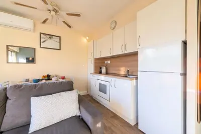 a kitchen with a couch and a white refrigerator at Résidence 2p Proche Plage Et Croisette, Palm Beach - 2P Proche Plage et Croisette, Palm Beach MAE-2193 in Cannes