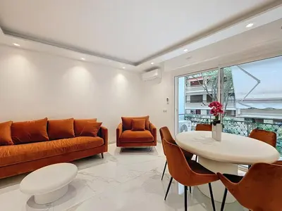 a living room with a couch and a table and chairs at Executive 2BR Apartment near Croisette Ideal for MIPIM Terrace & Wi-Fi in Cannes