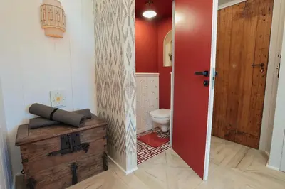 a bathroom with a toilet and a red door at Charmant studio dans la Californie in Cannes