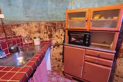 a dirty kitchen with a sink and a microwave at Charmant studio dans la Californie in Cannes