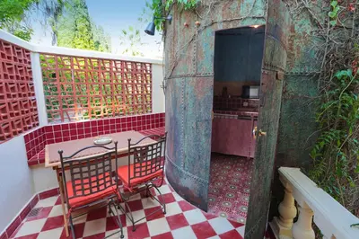 a red chair on a balcony with a table at Charmant studio dans la Californie in Cannes