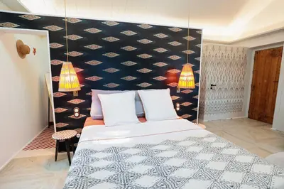 a bedroom with a large bed with a black and white patterned wall at Charmant studio dans la Californie in Cannes