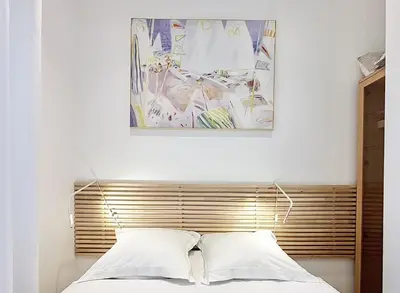 a bed with a wooden headboard with a painting above it at Cannes One Bedroom Apartment - 85M in Cannes