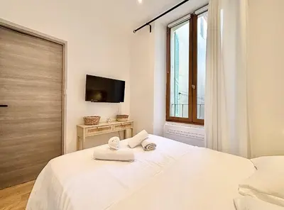 a white bedroom with a bed with towels on it at Cannes One Bedroom Apartment - 85M in Cannes
