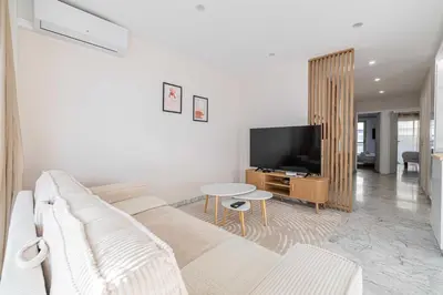 a living room with a white couch and a tv at Elegant apt with balcony near the beaches – Cannes in Cannes