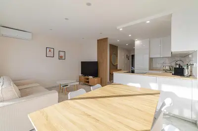 a kitchen and living room with a table in a room at Elegant apt with balcony near the beaches – Cannes in Cannes