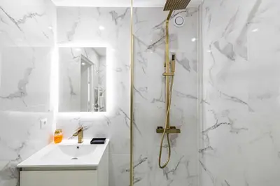 a white bathroom with a shower and a sink at Elegant apt with balcony near the beaches – Cannes in Cannes