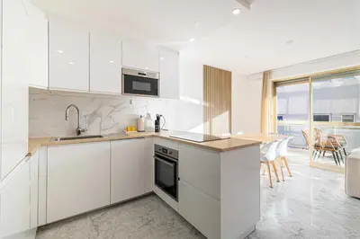 a white kitchen with a sink and a stove at Elegant apt with balcony near the beaches – Cannes in Cannes