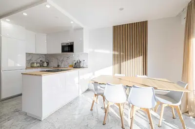 a kitchen with a wooden table and white chairs at Elegant apt with balcony near the beaches – Cannes in Cannes