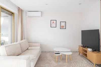 a white living room with a white couch and a table at Elegant apt with balcony near the beaches – Cannes in Cannes
