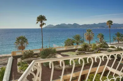 a staircase leading to the ocean with palm trees at Cannes Sunset & Sea Apartment in Cannes