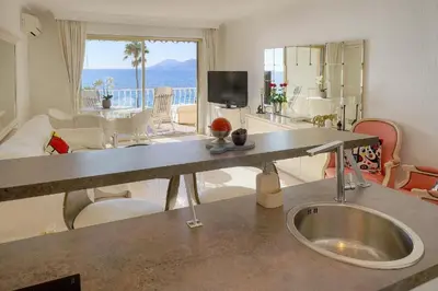 a kitchen with a sink in the middle of a living room at Cannes Sunset & Sea Apartment in Cannes