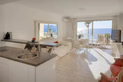 a kitchen and living room with a view of the ocean at Cannes Sunset & Sea Apartment in Cannes
