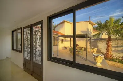 a house with a large window with a view of a patio at FRGK Villa Contemporaine Studio Indépendant Piscine, Calme Vue Dégagée in Le Cannet