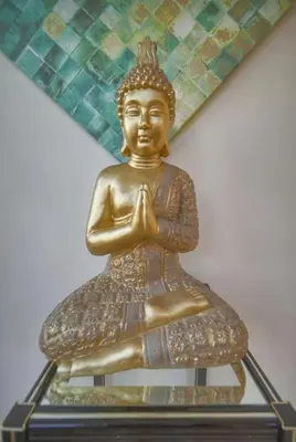 a golden statue of a buddha sitting on a table at FRGK Villa Contemporaine Studio Indépendant Piscine, Calme Vue Dégagée in Le Cannet