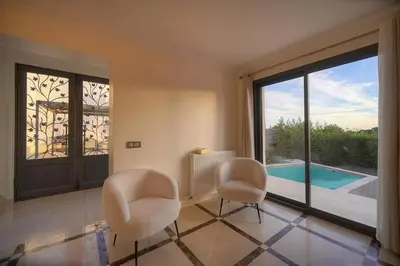 a living room with two chairs and a large window at FRGK Villa Contemporaine Studio Indépendant Piscine, Calme Vue Dégagée in Le Cannet