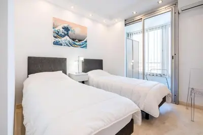 two beds in a room with a wave on the wall at Résidence 3p De Style, Résidence Sécurisée Sur La Croisette - 3P de style, résidence sécurisée sur la Croisette MAE-1993 in Cannes