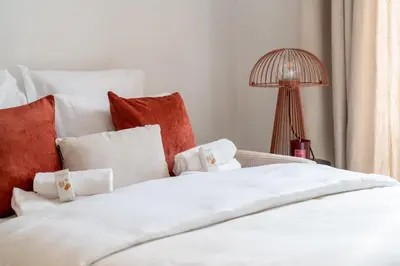 a white bed with red and white pillows and a lamp at Hyper centre Cannes - 2 pièces avec balcon - 4 couchages in Cannes