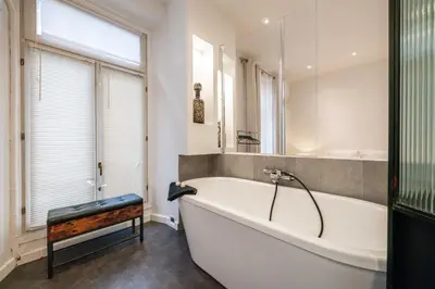 a white bath tub in a bathroom with a window at Hyper centre Cannes - 2 pièces avec balcon - 4 couchages in Cannes