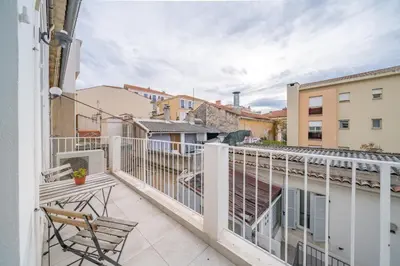 a balcony with a wooden chair on a building at Hyper centre Cannes - 2 pièces avec balcon - 4 couchages in Cannes