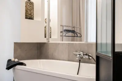 a white bath tub in a bathroom with a window at Hyper centre Cannes - 2 pièces avec balcon - 4 couchages in Cannes
