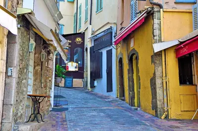 an alley with buildings and a table on a street at le Festivalier - spacieux, bien équipé, piéton in Cannes