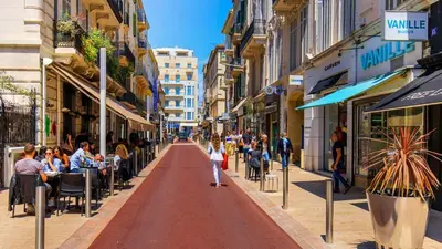 a street in a city with people sitting in cafes at le Festivalier - spacieux, bien équipé, piéton in Cannes