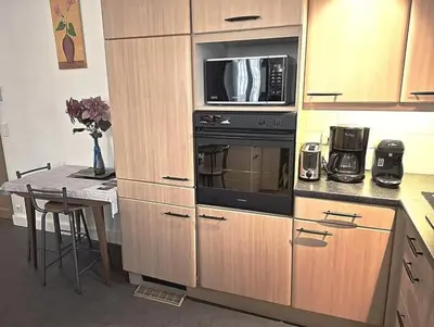 a kitchen with a stove and a microwave and a table at le Festivalier - spacieux, bien équipé, piéton in Cannes