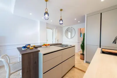 a kitchen with white cabinets and a counter top at 3-Br Apartment Sea View Terrace & Parking in Cannes