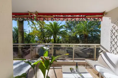 a room with a large window with palm trees at 3-Br Apartment Sea View Terrace & Parking in Cannes
