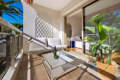 a balcony with a couch and a table at 3-Br Apartment Sea View Terrace & Parking in Cannes