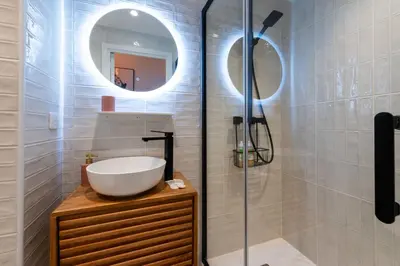 a bathroom with a sink and a shower with a mirror at 3-Br Apartment Sea View Terrace & Parking in Cannes