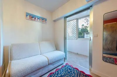 a living room with a couch and a window at 3-Br Apartment Sea View Terrace & Parking in Cannes
