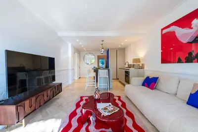 a living room with a couch and a tv at 3-Br Apartment Sea View Terrace & Parking in Cannes