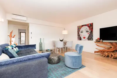 a living room with a blue couch and a tv at 5 Croisette 6 in Cannes