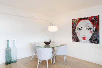 a dining room with a table and a painting of a woman at 5 Croisette 6 in Cannes