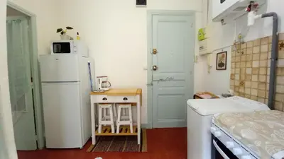 a small kitchen with a refrigerator and a small table at Studio Forville in Cannes