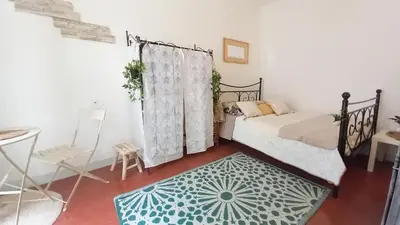 a bedroom with a bed and a table and a chair at Studio Forville in Cannes