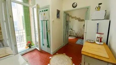 a kitchen with a refrigerator and a room with a table at Studio Forville in Cannes