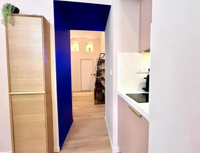 a hallway leading to a kitchen with a blue wall at Le Borniol in Cannes