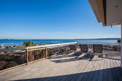 a balcony with two chairs and a view of the ocean at REF 2033 - Cannes - Sumptuous penthouse with sea view for rent in Cannes
