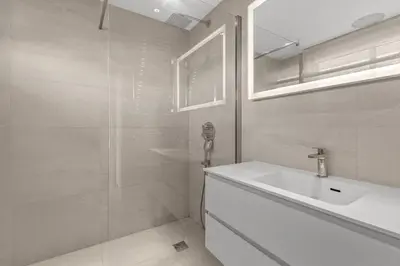 a white bathroom with a sink and a shower at REF 2033 - Cannes - Sumptuous penthouse with sea view for rent in Cannes