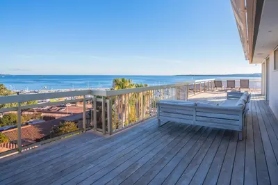 a bench on a deck with a view of the ocean at REF 2033 - Cannes - Sumptuous penthouse with sea view for rent in Cannes