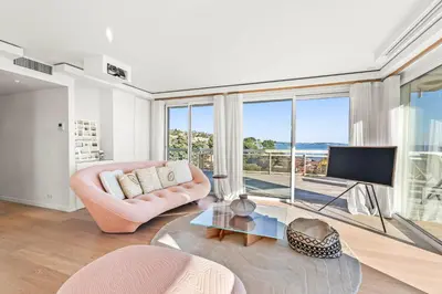 a living room with a pink chair and a television at REF 2033 - Cannes - Sumptuous penthouse with sea view for rent in Cannes