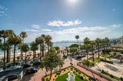 a view of a city with palm trees and a street at REF 1295 - Cannes Croisette - Sea view apartment for rent in Cannes