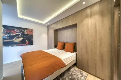 a bedroom with a bed and a wooden wall at REF 1295 - Cannes Croisette - Sea view apartment for rent in Cannes