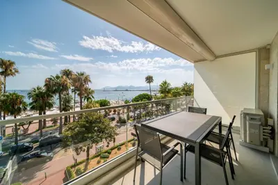 a balcony with a table and chairs and a view of the ocean at REF 1295 - Cannes Croisette - Sea view apartment for rent in Cannes