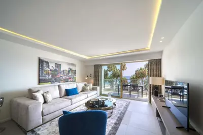 a living room with a couch and a tv at REF 1295 - Cannes Croisette - Sea view apartment for rent in Cannes