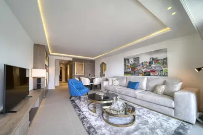 a living room with a couch and a tv at REF 1295 - Cannes Croisette - Sea view apartment for rent in Cannes