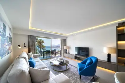 a living room with a white couch and blue chairs at REF 1295 - Cannes Croisette - Sea view apartment for rent in Cannes